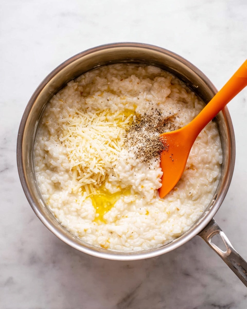 A close-up of round golden brown fried balls with a crispy texture, stacked on a white plate. Each ball is covered in coarse crumbs and topped with small white salt flakes. The plate sits on a soft white cloth, all placed on a white marbled surface. The lighting shows the crunchy and slightly oily exterior of the balls, making them look warm and fresh. photo taken with an iphone --ar 4:5 --v 7