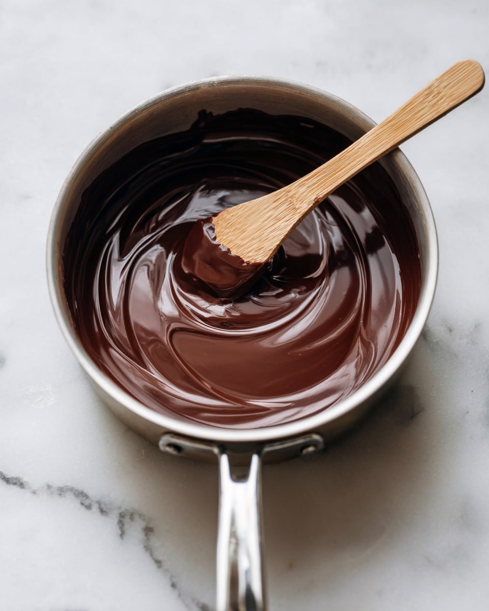 A white bowl filled with five smooth, round scoops of chocolate ice cream stacked closely together, each scoop showing a creamy texture with small chocolate chunks visible. The ice cream is rich brown in color with a slight shine, and a bit of melted ice cream drips gently over the edge of the bowl. Small pieces of broken chocolate and cocoa powder are scattered around the bowl, set on a white marbled surface. The photo taken with an iphone --ar 4:5 --v 7