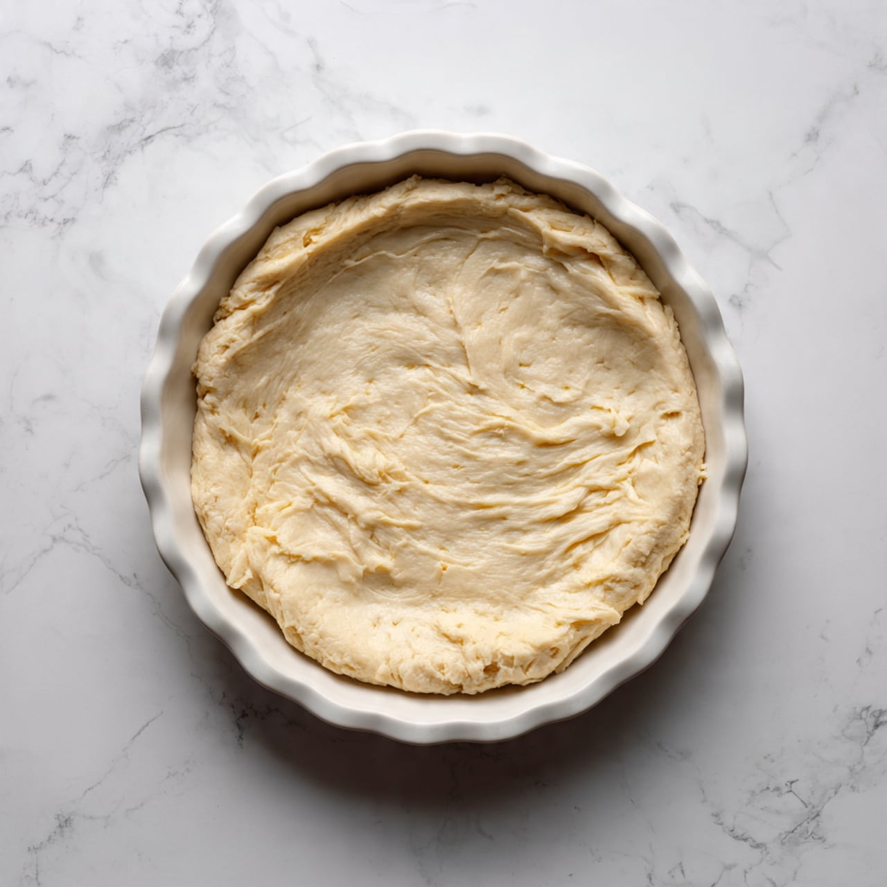 A round apple pie with a golden brown lattice crust sits in a white pie dish on a silver cooling rack, which is placed on a white marbled surface. The crust is thick and flaky with visible sugar crystals on top, showing a slightly uneven, homemade texture. The lattice pattern is made of wide strips of crust woven over one another, revealing bits of light yellow apple filling beneath. The edges of the crust are crimped with a rustic, wavy design, showing some deeper browning than the rest. Photo taken with an iphone --ar 4:5 --v 7