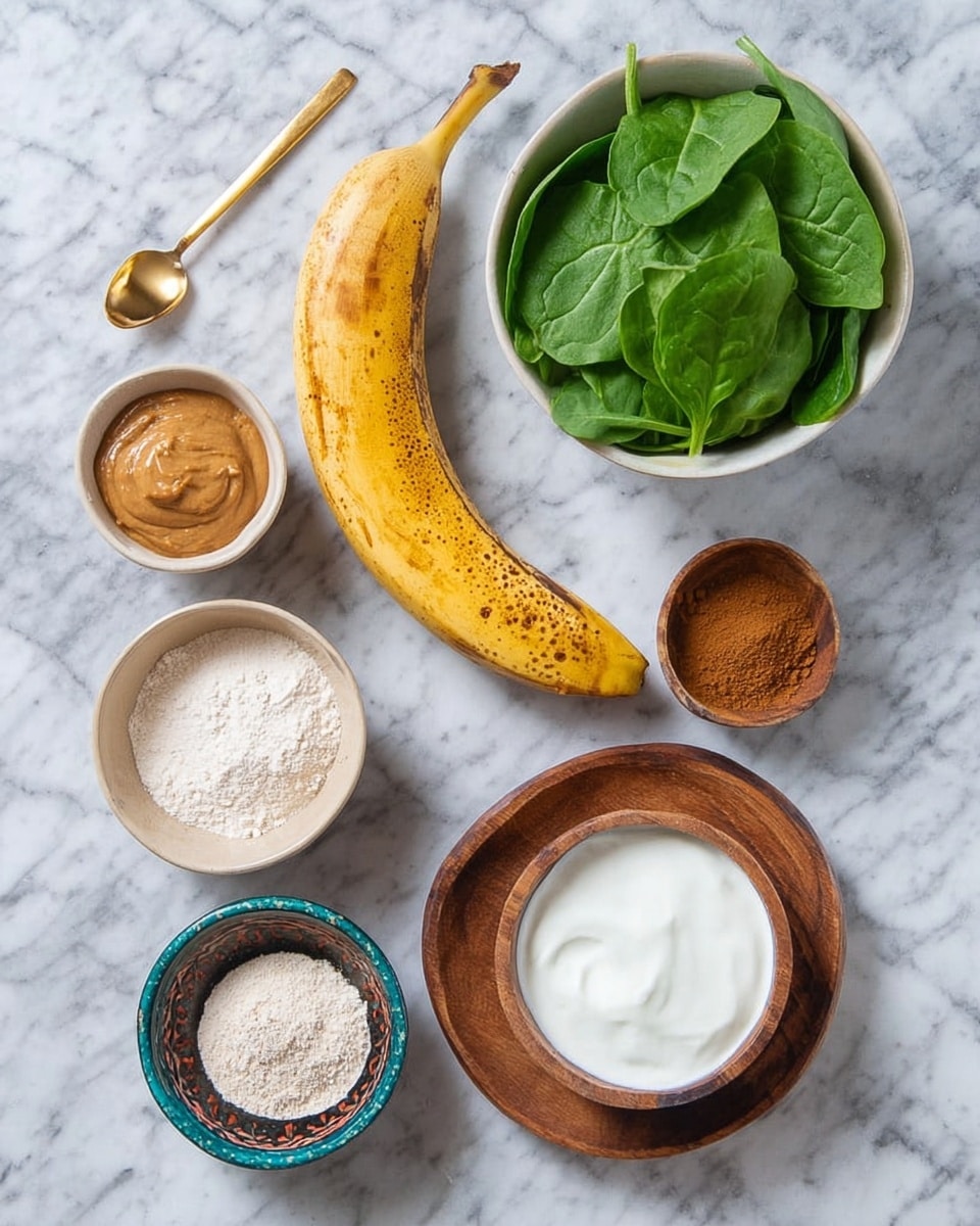 The image shows seven ingredients placed on a white marbled surface. In the center, there is a yellow banana with some brown spots on its peel. To the right of the banana, there is a white bowl filled with green spinach leaves. Above the banana, there is a small white bowl with light brown nut butter, smooth in texture. To the upper left, there is a small beige bowl holding a golden spoon and some powder. Below that, there is a round wooden bowl filled with white powder. To the lower left of the banana, a small round bowl with a blue and brown pattern holds some ground cinnamon or similar brown spice. To the right of the banana and beside the spinach, there is a round wooden bowl filled with white yogurt or a creamy substance. The photo was taken with an iphone --ar 4:5 --v 7