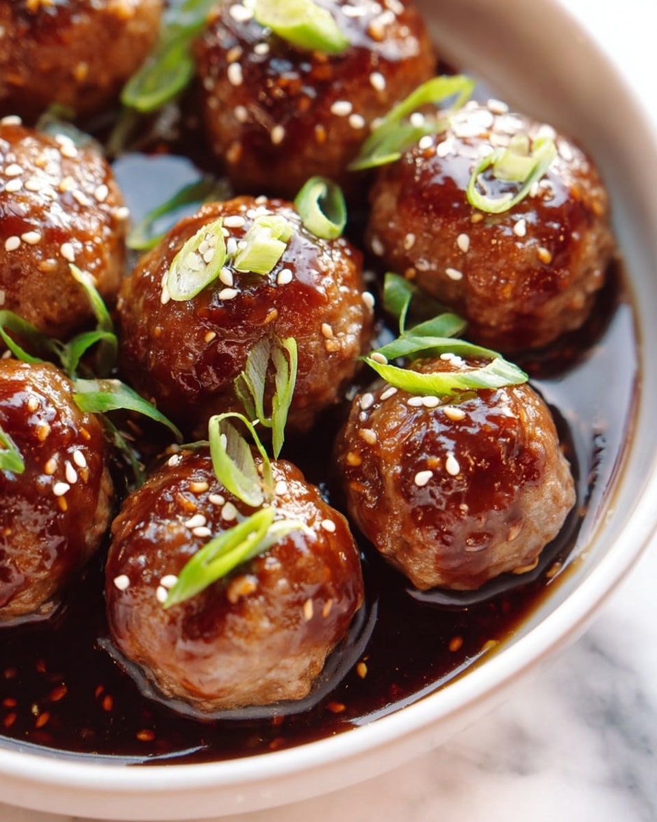 A close-up shows a metal bowl filled with small raw meatballs, about a dozen, each shaped into a round form and speckled with small green herbs. The meatballs have a light pink color with a slightly uneven but moist texture, resting against the shiny, smooth inner surface of the bowl. The white marbled surface underneath adds a clean and bright contrast to the scene. photo taken with an iphone --ar 4:5 --v 7