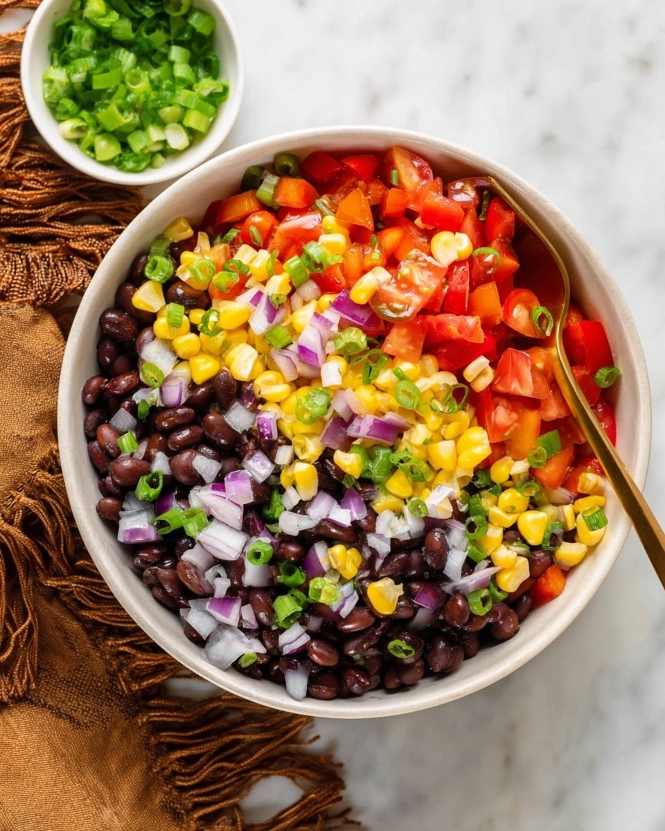 A white bowl filled with a colorful mix of chopped vegetables arranged in distinct layers: at the bottom, yellow corn kernels with small pieces of red onion, above that, bright red cherry tomatoes cut in halves and quarters, then chopped red bell pepper, and finally topped with fresh, green chopped scallions evenly scattered over the top. A gold spoon is resting inside the bowl on the right side. The bowl is placed on a white marbled surface. Photo taken with an iphone --ar 4:5 --v 7