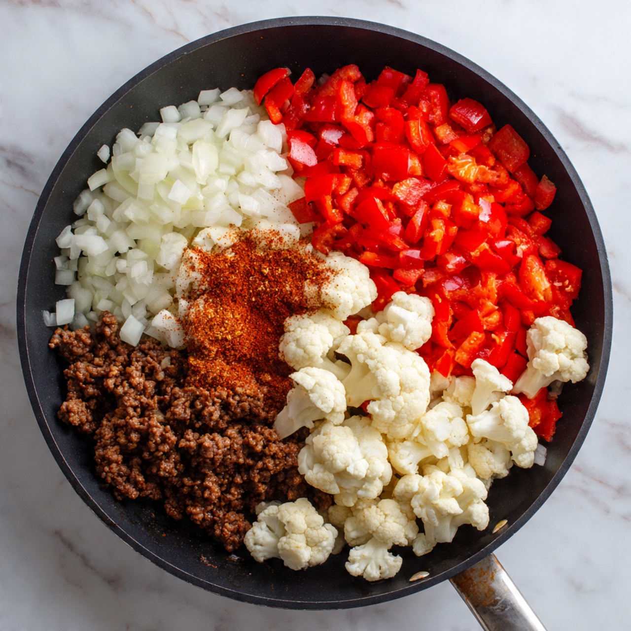 Two white bowls filled with a colorful mixture of cooked ground meat, bright orange cauliflower pieces, chopped red bell peppers, wilted green spinach, and translucent cooked onions. The ingredients are evenly mixed, showing a variety of small and chunky textures with the cauliflower and meat standing out. One bowl has a spoon inside, and the background features a white marbled surface with a yellow textured cloth nearby. photo taken with an iphone --ar 4:5 --v 7