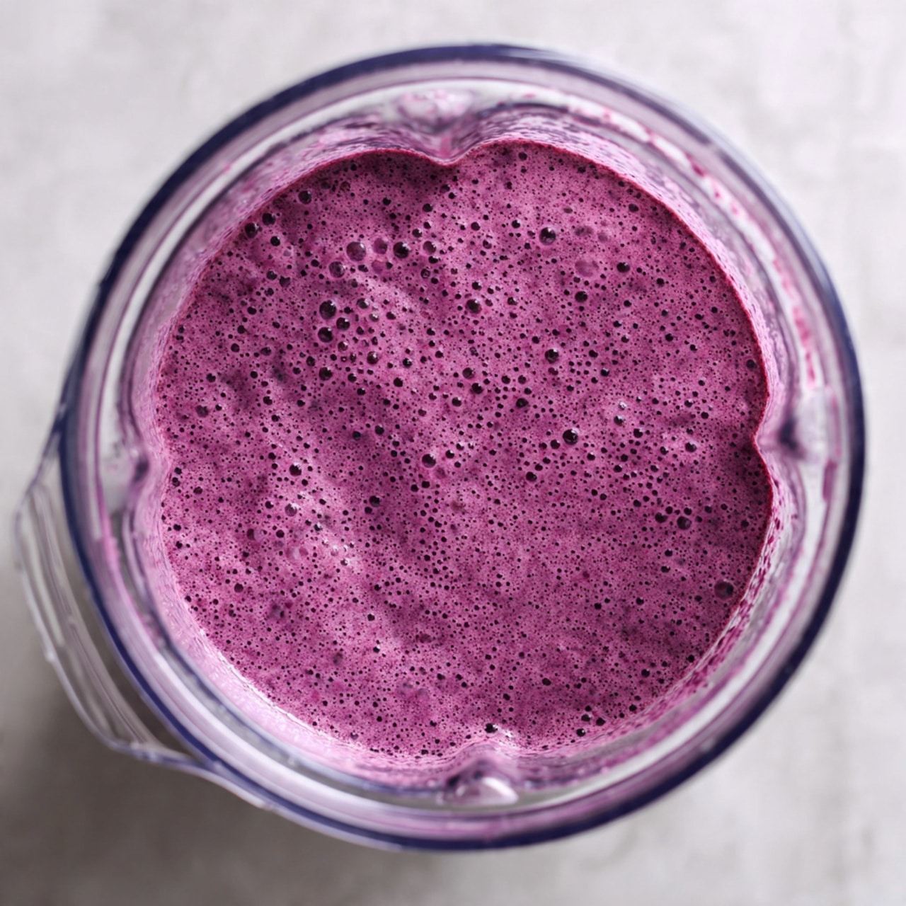 The image shows several purple popsicles with a smooth, slightly textured surface laid out on a white marbled surface. The popsicles have wooden sticks and are arranged overlapping each other, creating a layered effect. Scattered around and on top of the popsicles are fresh blueberries, adding a dark blue contrast to the purple shades. The shadows and lighting highlight the cool and fresh look of the popsicles and berries. photo taken with an iphone --ar 4:5 --v 7
