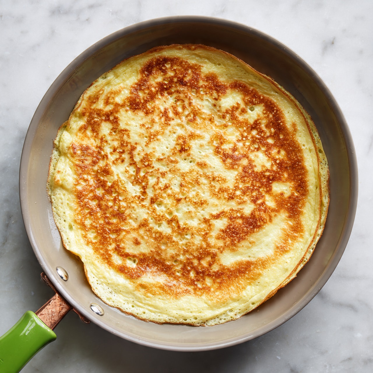A large round white plate holds a colorful fried rice dish with many thin layers mixed together. The base layer is white rice, scattered with light brown chicken pieces. Mixed throughout are thin strips of pale green cabbage, thin orange carrot shreds, bright green peas, and chopped green onions. The vegetables and rice are evenly spread, creating a mix of soft rice and fresh greens. The texture looks fluffy, with small bits of egg visible, adding a pale yellow color. In the background, a white bowl with fresh green herbs sits on a white marbled surface. Photo taken with an iphone --ar 4:5 --v 7