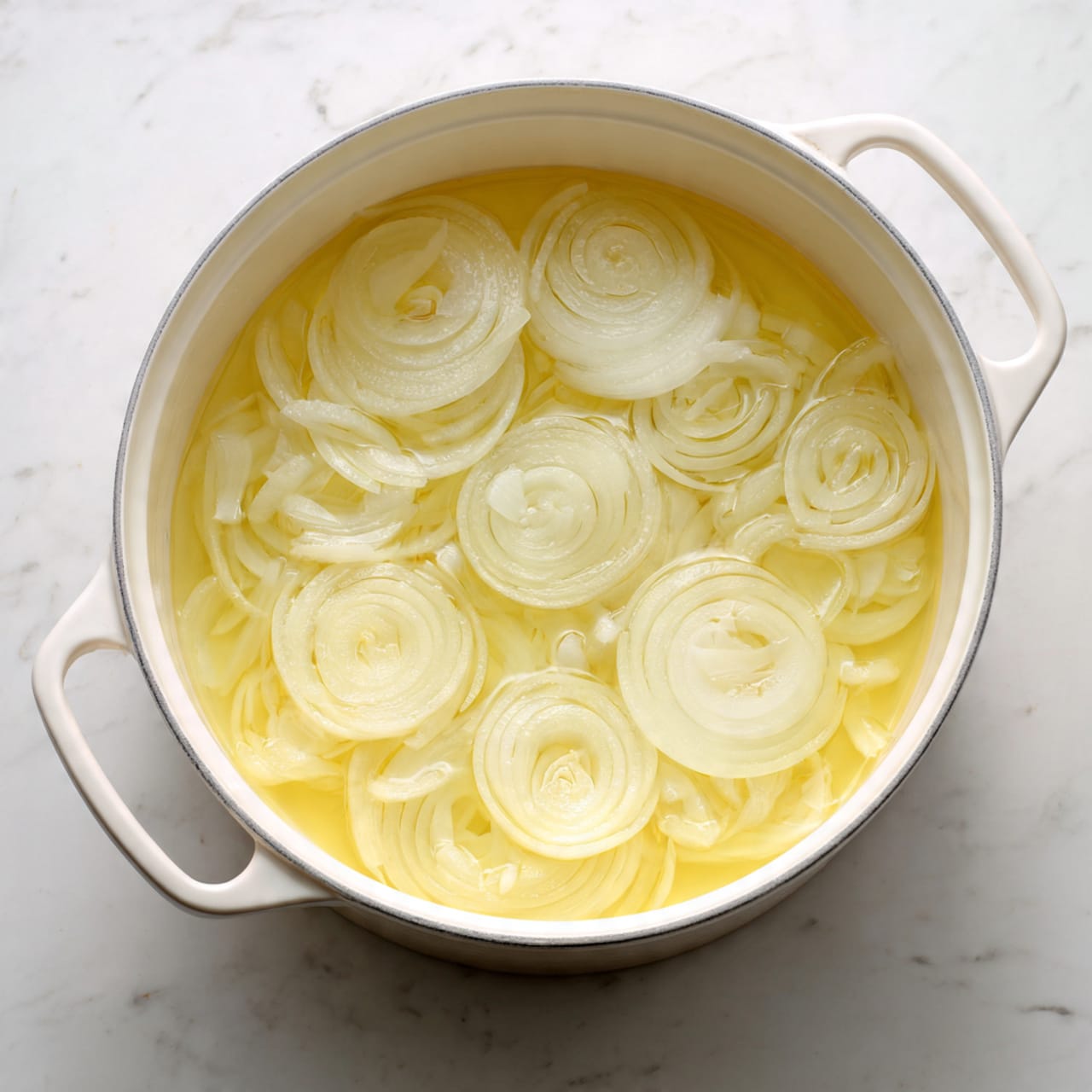 A white shallow bowl holds a serving of yellow rice mixed with small grains, with a small pat of butter melting in the center, showing a soft, fluffy texture; the rice fills most of the bowl's base in one even layer. There is an old metal spoon resting in the rice on the right side of the bowl. Behind it, a white pot with two handles contains more of the yellow rice topped with a dollop of white sauce, with the inside texture of the pot showing bits of rice stuck to the sides. To the left, a small white bowl filled with white sauce and a spoon stands on a white marbled surface. In the bottom left corner, a small white dish contains another dollop of butter. A woman’s hand is partly visible holding a fork near the bowl. A yellow and black striped cloth lies folded to the right on the white marbled surface. Photo taken with an iphone --ar 4:5 --v 7
