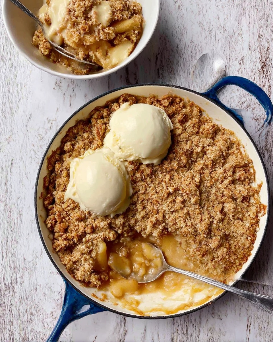 The image shows a white round pan with two blue handles filled with a golden brown crumbly topping covering soft cooked fruit beneath. Two dollops of light creamy sauce sit on top near the center. A silver spoon rests inside the pan next to a scoop taken out showing the soft, juicy fruit layer under the crunchy topping. In the background on a white marbled surface, there is a white bowl filled with a serving of the same dessert topped with more creamy sauce, and a silver spoon inside. A woman's hand holds the bowl from behind. The surface under everything is a white marbled texture. photo taken with an iphone --ar 4:5 --v 7