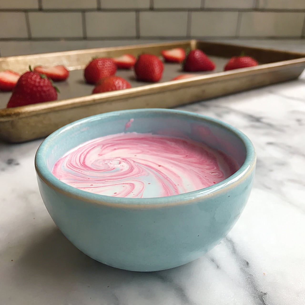 The image shows a baking tray filled with small strawberry cups, each made from a strawberry hollowed out at the top, with the bottom half dipped in smooth, dark chocolate. The strawberries are bright red with their seeds visible, and the chocolate is glossy and dark brown. They are arranged neatly in rows, covering the tray, which is placed on a white marbled surface with a pale green brick wall background. The photo is taken at a slight angle showing the detailed texture of the strawberries and chocolate. Photo taken with an iphone --ar 4:5 --v 7