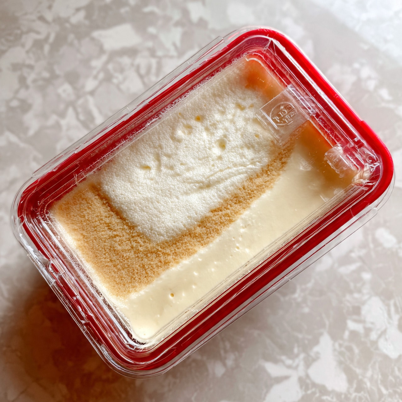 The image shows a close-up of a large amount of thick, smooth white cream with soft, swirled peaks and ridges. The texture looks light and fluffy, filling the entire frame with curved, flowing lines that create a sense of movement. The background features a white marbled texture, giving a clean and simple look without any visible container edges. photo taken with an iphone --ar 4:5 --v 7