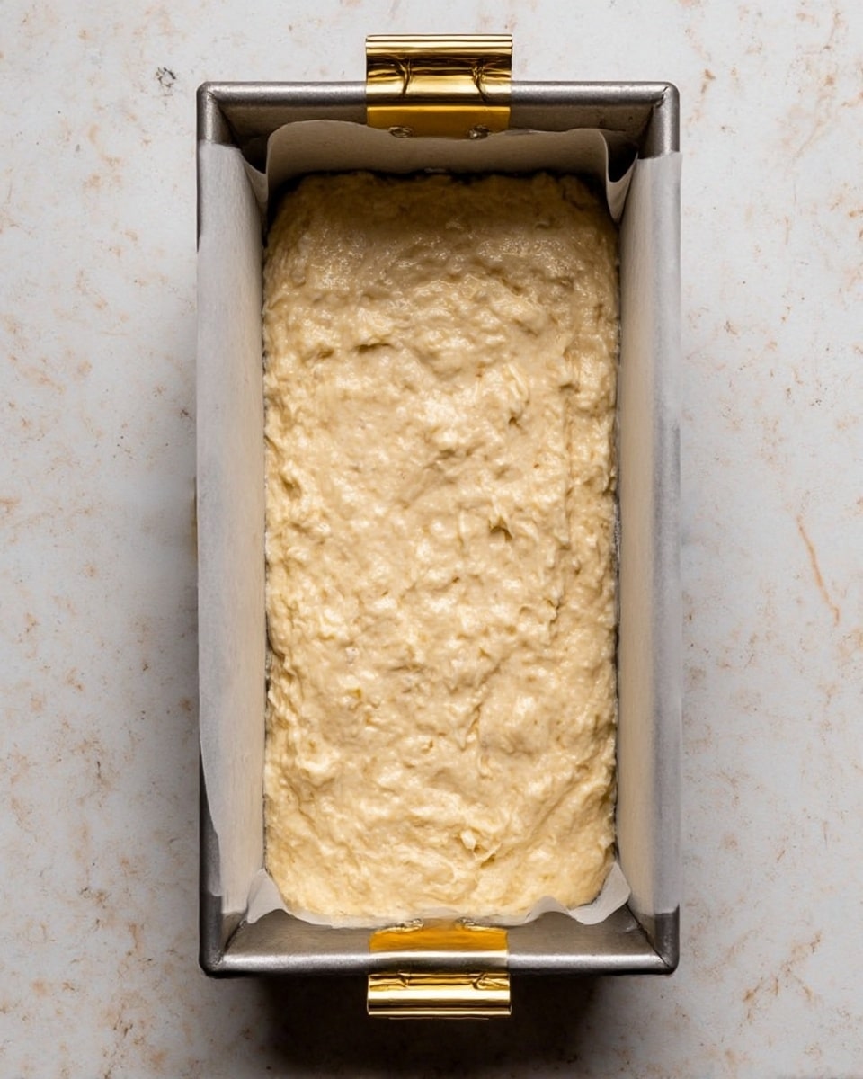 A loaf of banana bread is sliced into several pieces and placed on a wire cooling rack over a white marbled surface. The bread has a golden brown crust with a soft, light brown crumb showing visible banana bits inside. One slice is laid flat in front, spread with a layer of creamy butter that is partially melted, and the edge of this slice has a small bite taken out. Next to the bread is a butter knife with some butter on the blade. A ripe banana with brown spots lies in the background to the right. The overall scene is warm and inviting, showing the texture and detail of the bread clearly. Photo taken with an iphone --ar 4:5 --v 7