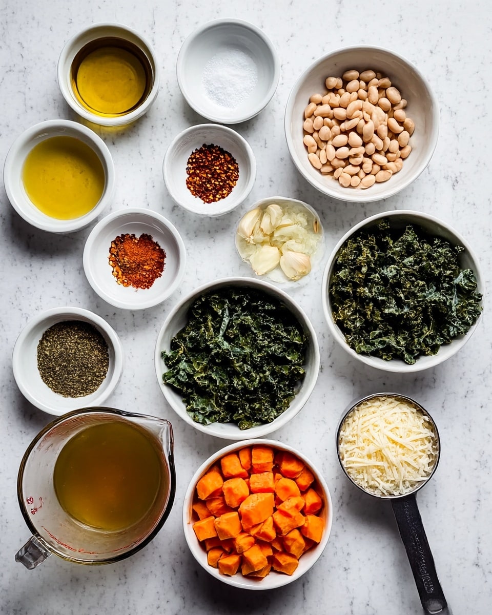 A shallow white bowl holds a warm stew with three main layers: the base layer is a golden orange mashed vegetable, likely squash, with a soft texture; the middle layer is white beans scattered generously across the bowl; the top layer consists of finely chopped dark green kale mixed evenly among the beans. The stew is thick and slightly shiny with visible specks of black pepper and red chili flakes sprinkled on the surface. A piece of toasted crusty bread rests partially inside the bowl on the left side while a silver spoon sits on the right side, partially submerged in the stew. The bowl is placed on a white marbled surface with small bowls of spices and a basket of more bread in the background, while a gray cloth is casually draped nearby photo taken with an iphone --ar 4:5 --v 7
