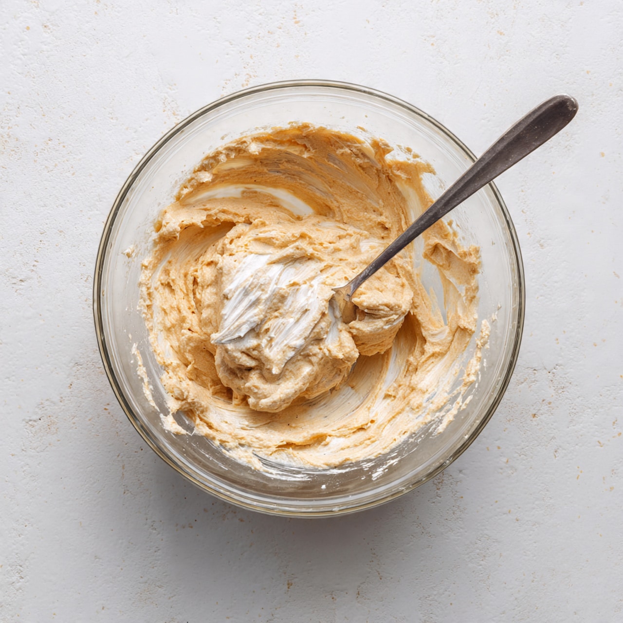 The image shows a white plate with six small sushi cups made from dark green seaweed shaped into little bowls. Each cup is filled with white rice at the bottom, topped with a layer of orange-colored tuna mixture. On top of the tuna, there is a light cream sauce drizzled over, sprinkled with small black sesame seeds. Small green onion slices and tiny pieces of cucumber are added on top, giving some fresh green color. The plate is on a wooden textured surface. photo taken with an iphone --ar 4:5 --v 7