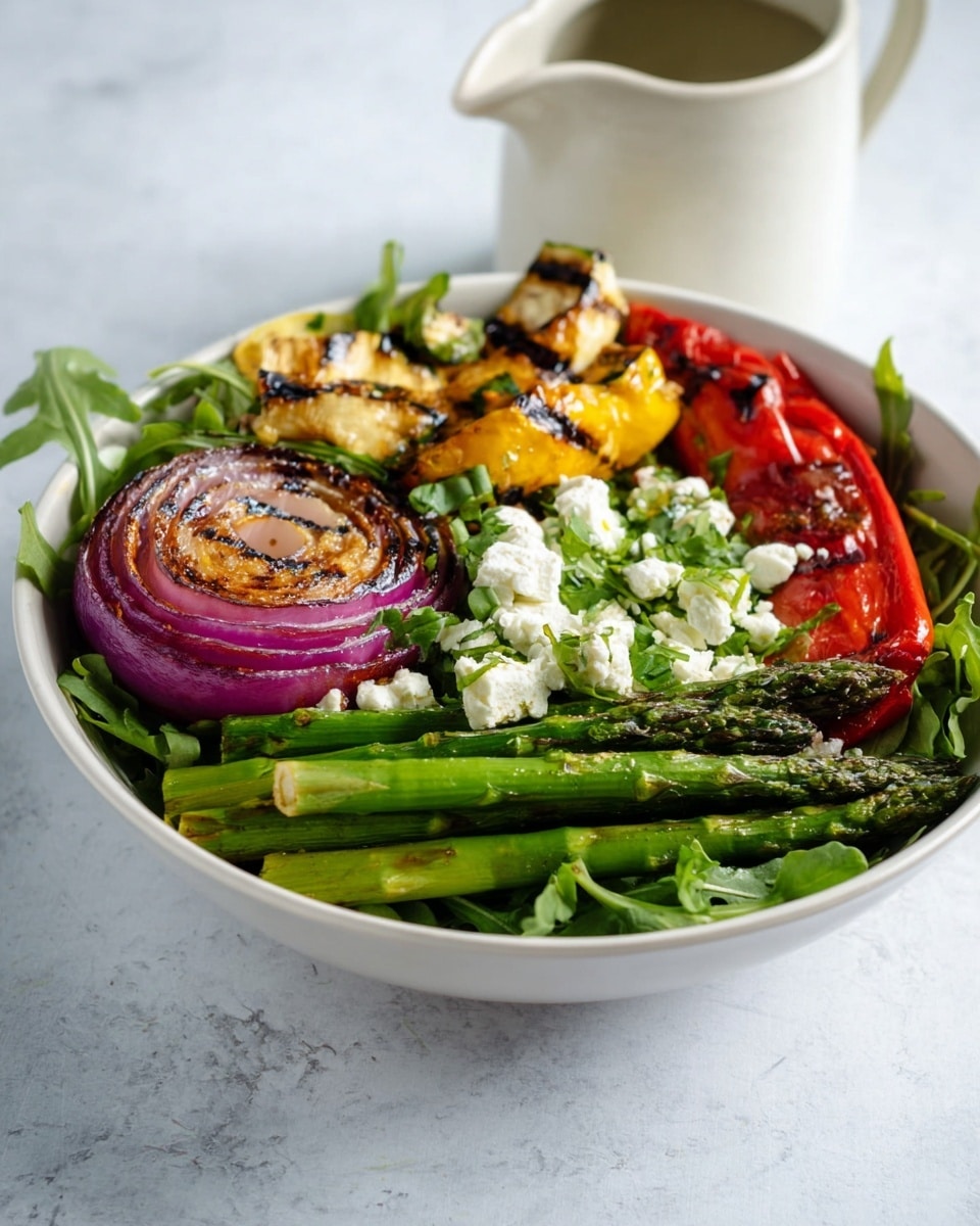 A white bowl sits on a white marbled surface filled with a fresh salad made of four main layers. The bottom layer is a bed of green arugula leaves spread evenly around the bowl. On top of the greens, bright green asparagus spears are laid close together on one side. There is a large round slice of grilled red onion with purple and brown shades near the bottom left of the bowl. Grilled yellow zucchini slices and a long red roasted pepper rest toward the center and right side. Scattered white chunks of feta cheese and finely chopped green herbs add texture and brightness over the top. A white ceramic jug is blurred in the background, enhancing the fresh and wholesome feel of the scene. photo taken with an iphone --ar 4:5 --v 7