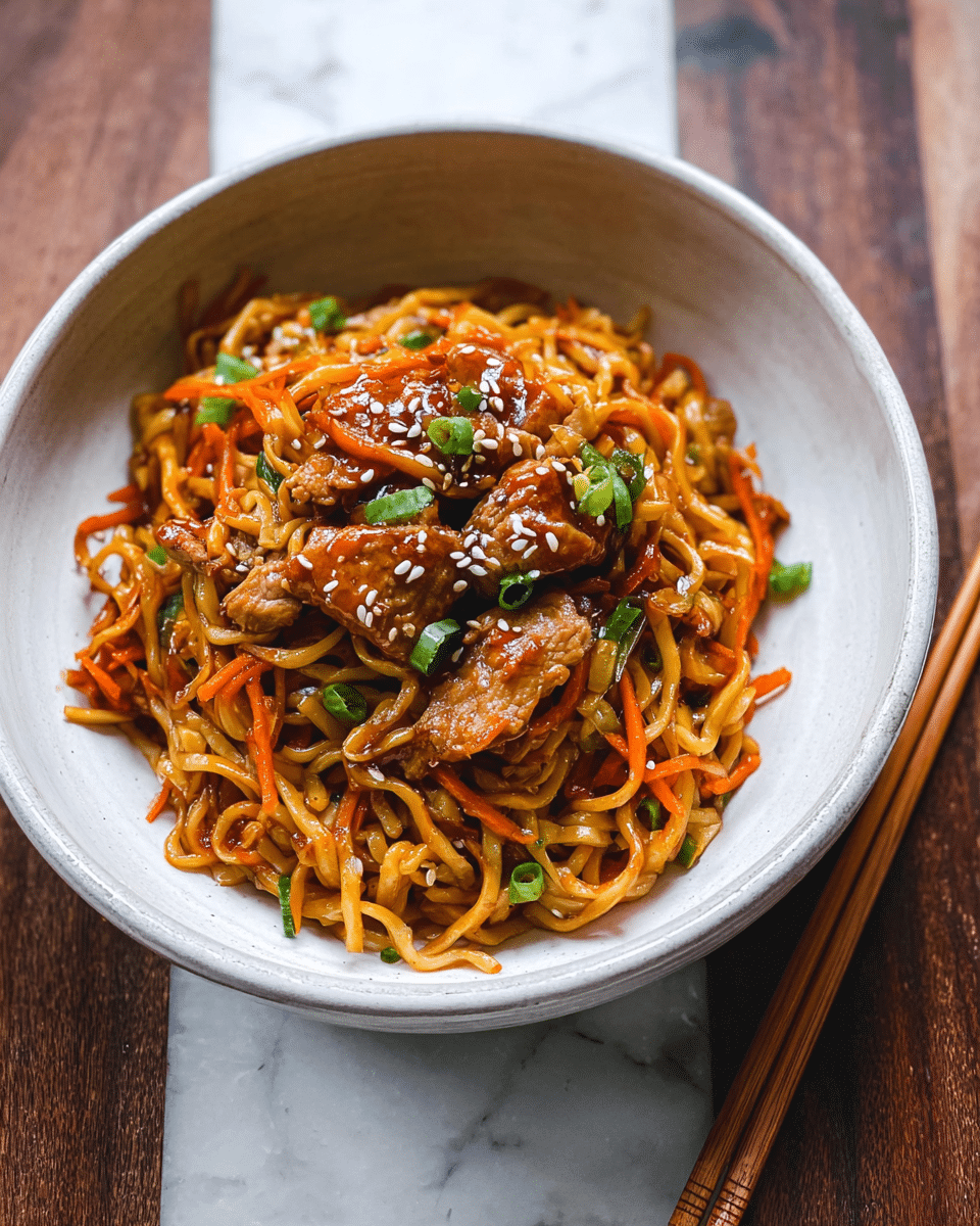 This image shows a close-up of a black pan filled with cooked noodles mixed with pieces of chicken, thin carrot strips, and green onion slices. The noodles are golden-brown and glossy, coated with a sauce, and sprinkled with small white sesame seeds. The chicken pieces are light brown with a shiny surface, scattered evenly through the noodles. A pair of metal chopsticks hold up a clump of noodles and chicken from the pan. The background is a white marbled texture. photo taken with an iphone --ar 4:5 --v 7