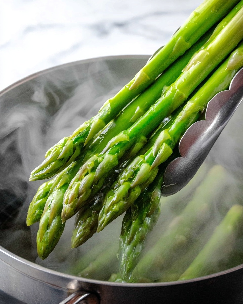 A close-up view of bright green asparagus spears held by silver tongs above a pot with steam rising, showing the fresh, smooth texture and pointed tips of the asparagus on a white marbled surface photo taken with an iphone --ar 4:5 --v 7