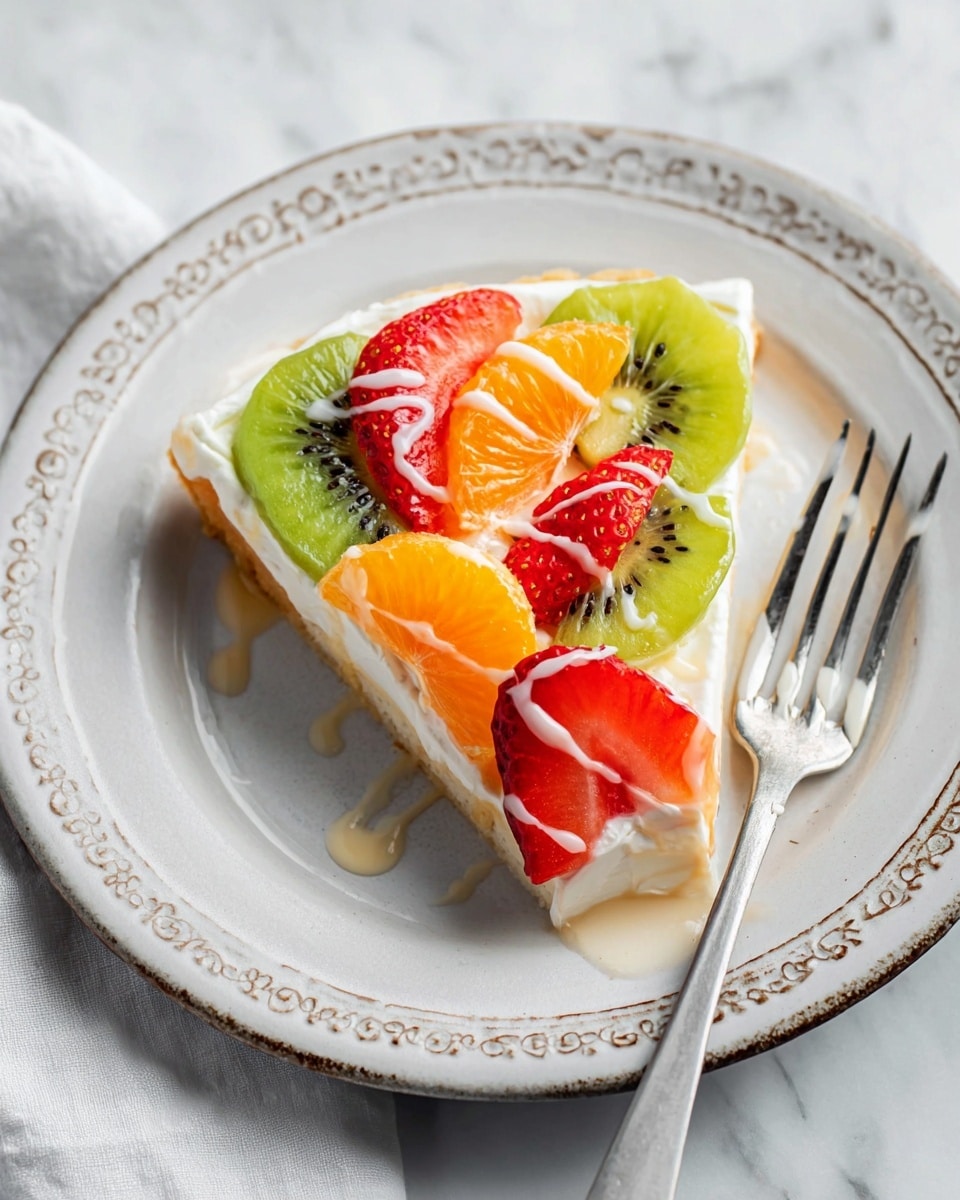 A slice of fruit tart is on a white plate with a beige rim and textured edges, placed on a white marbled surface. The tart has three layers: the bottom looks like a thin, light brown crust; the middle is a smooth white cream layer; and the top is covered with fresh fruit pieces, including bright green kiwi slices, orange mandarin segments, and red strawberry halves. There is a light drizzle of white icing over the fruit. A silver fork rests on the left side of the plate. Photo taken with an iphone --ar 4:5 --v 7