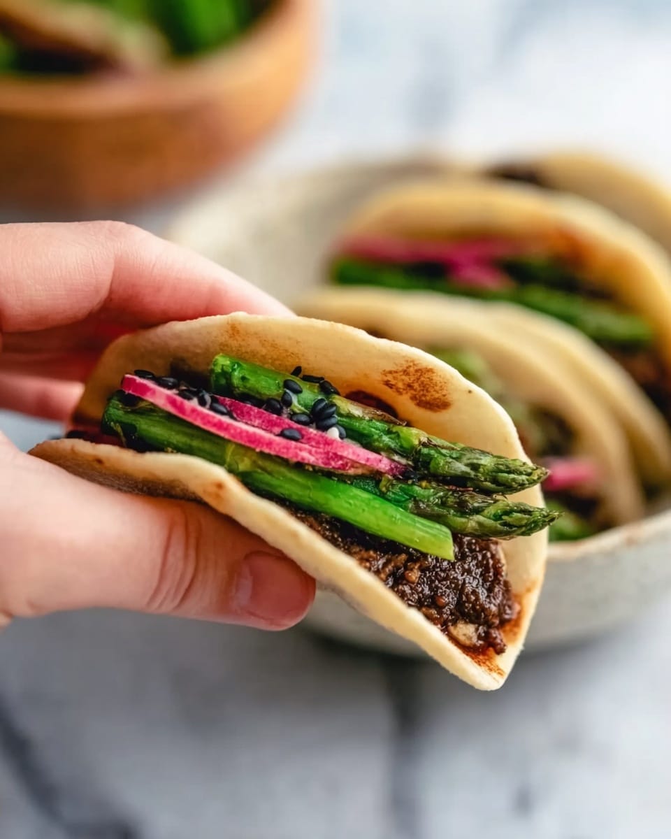 A round brown bowl holds ten small, white soft flatbreads, each topped with a browned patty, thin pink pickled onion slices, fresh green cilantro leaves, and small cucumber sticks, sprinkled with black sesame seeds. In the center of the bowl is a small beige cup filled with dark soy sauce that has red chili flakes floating on top. The bowl sits on a white marbled surface with some scattered cilantro leaves and black sesame seeds around. Photo taken with an iphone --ar 4:5 --v 7
