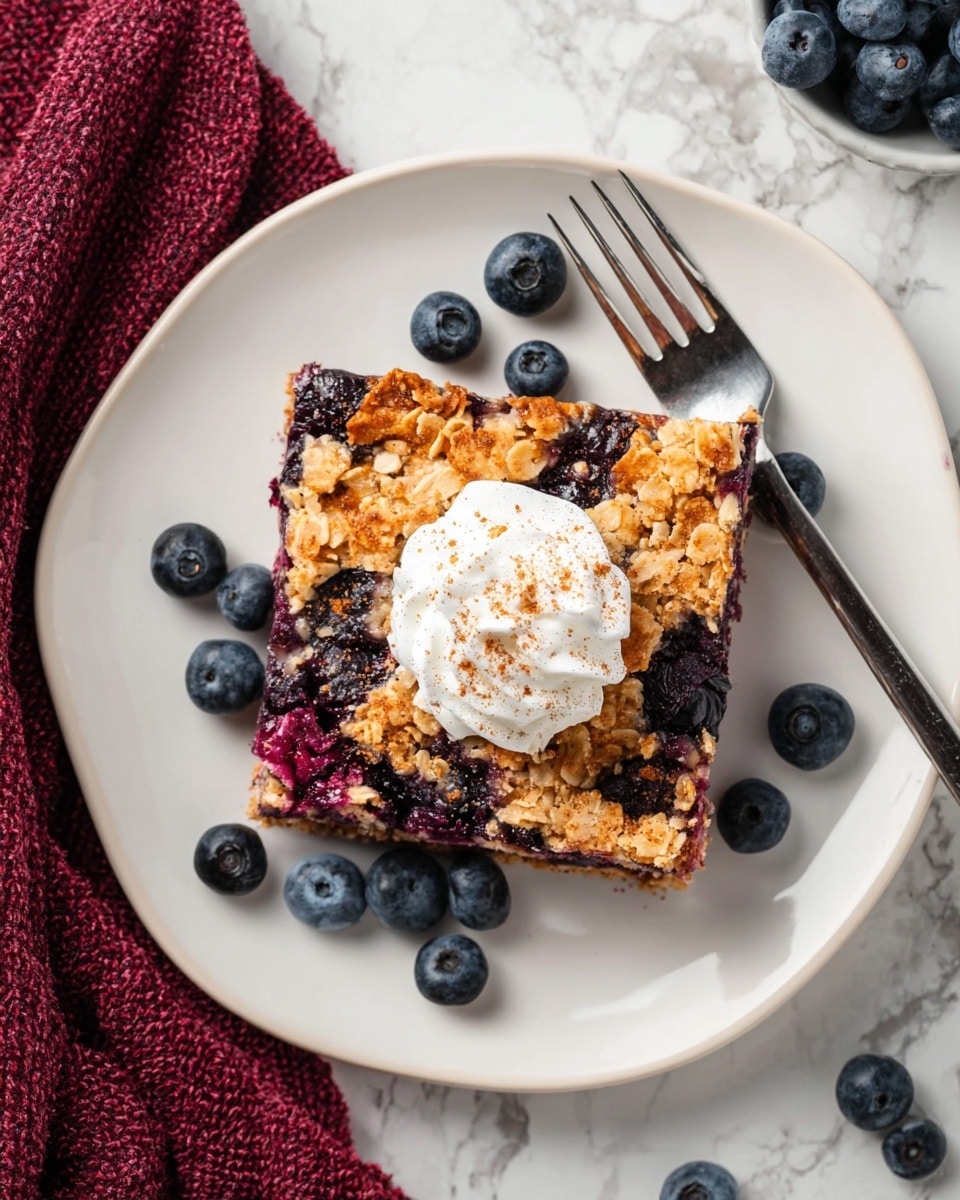 A rectangular white baking dish holds a baked oatmeal with blueberries, showing one thick layer where oatmeal and blueberries are mixed evenly. This layer is golden brown with a rough texture from the oats, and dark purple blueberry spots spread throughout. The edges of the oatmeal are slightly darker and crisp. The dish sits on a white marbled surface, with part of a wooden spatula visible in the top left corner and a small white bowl filled with fresh blueberries to the right. A dark reddish cloth is partially under the dish on the bottom right side. Photo taken with an iphone --ar 4:5 --v 7