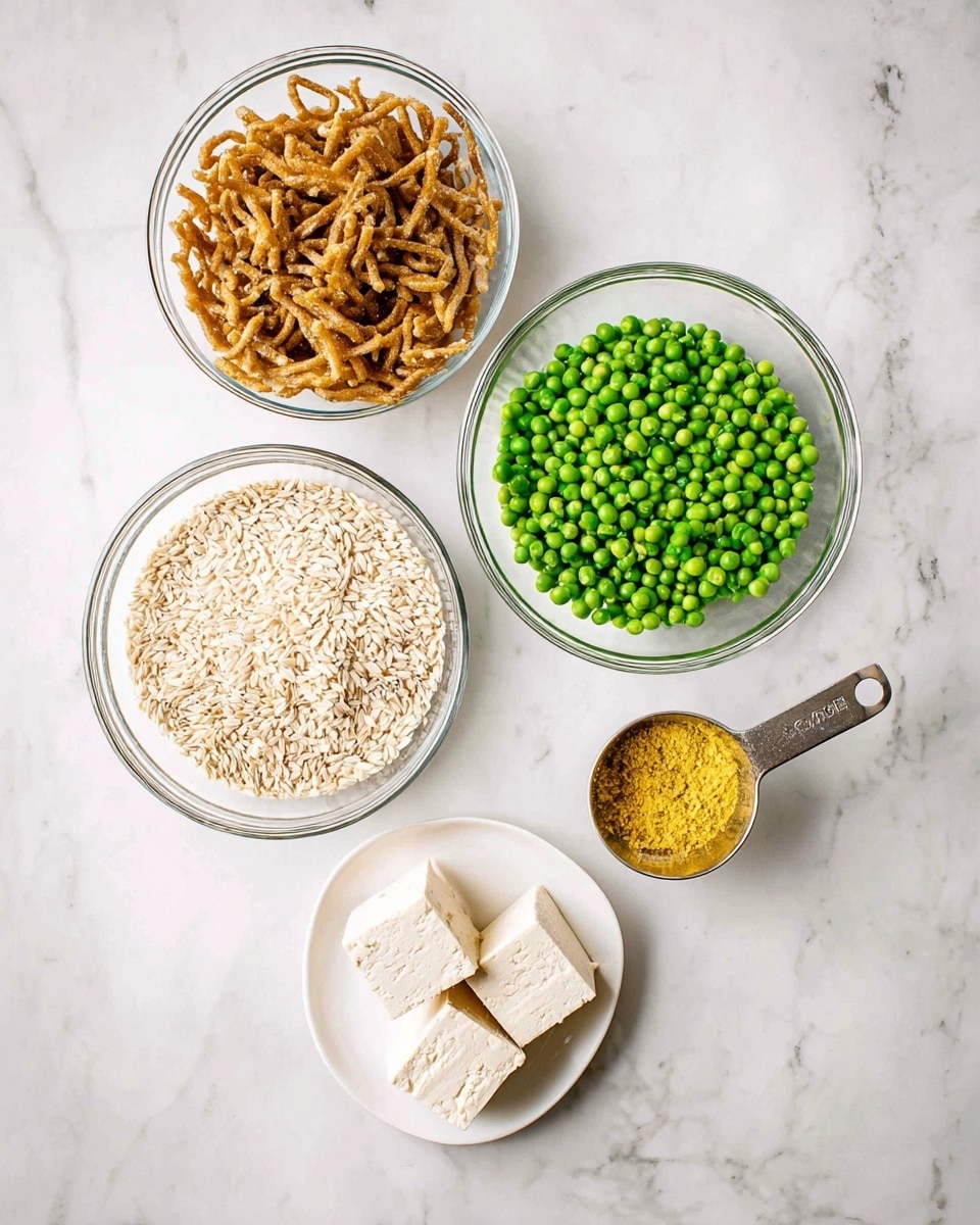 A white bowl sits on a wooden board over a white marbled surface, filled with yellow rice mixed with green peas and tender golden-brown strips of cooked chicken scattered on top and within the rice. A silver fork is resting inside the bowl on the left side. In the background, two smaller white bowls, one filled with green peas and the other with a light yellow sauce, are slightly out of focus. The dish has a warm, comforting look with soft textures and scattered bright green peas adding pops of color. photo taken with an iphone --ar 4:5 --v 7