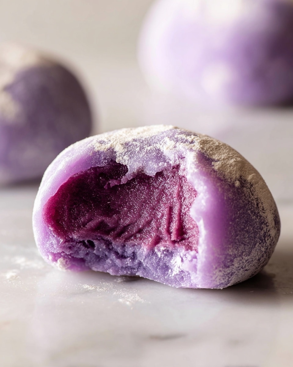 The image shows several round purple mochi ice creams with a soft, powdery white coating on the outside. Some of the mochi are whole, while others are cut in half, revealing three layers: the outer layer is a thin, pale purple mochi dough with a smooth and slightly frosty texture; inside is a thicker layer of rich, dense lavender ice cream; the center looks creamy and smooth with a slightly darker purple shade. They are placed on a white plate and a white marbled surface, with a small white bowl full of deep purple ice cream partially shown at the bottom right. Photo taken with an iphone --ar 4:5 --v 7