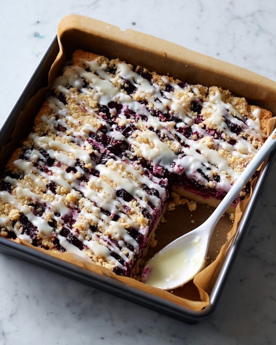 The image shows square blueberry dessert bars arranged on brown parchment paper on a white marbled surface. Each bar has three visible layers: the bottom layer is a thick, golden-brown crumbly crust, the middle layer is a dark purple-blue blueberry filling with visible berry pieces, and the top layer is a light, white glaze drizzled unevenly with some crumbly bits. One bar is turned on its side, showing the thickness of the crust and filling clearly. There are small purple stains from the blueberries on the parchment paper around the bars, adding a rustic touch. photo taken with an iphone --ar 4:5 --v 7