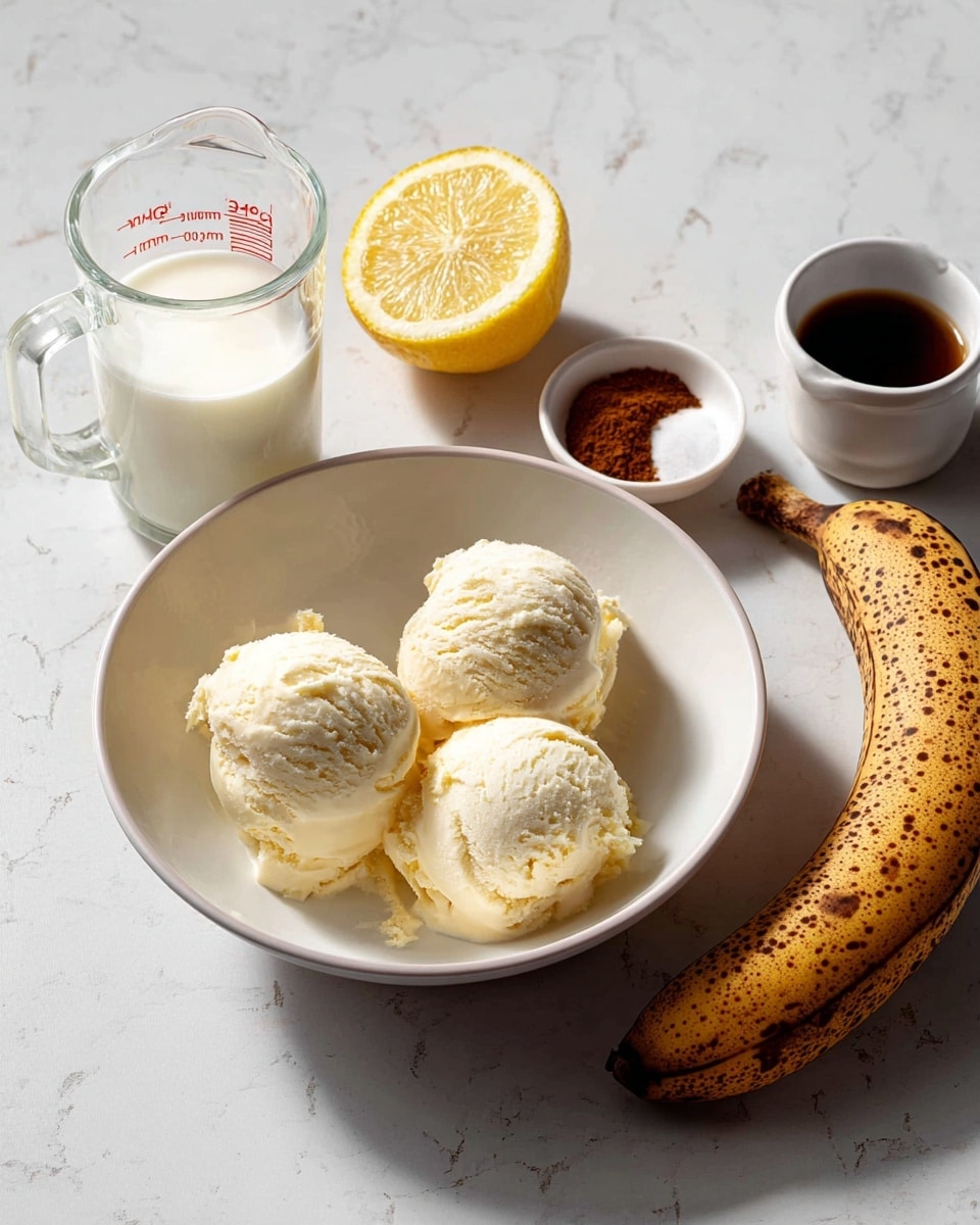 A clear glass is being filled with a creamy light tan smoothie from a pitcher, next to it is another tall clear glass filled to the top with the same smoothie and topped with a swirl of white whipped cream, both glasses stand on a round wooden board with a bunch of ripe yellow bananas to the right. The background shows a soft gray fabric and a white marbled surface below. photo taken with an iphone --ar 4:5 --v 7