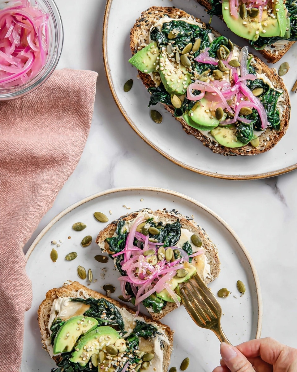 Two thick slices of seeded bread with a golden-brown crust lie next to a whole loaf on a white marbled surface. Below the bread, a whole avocado with a dark green, bumpy skin rests beside fresh, bright green spinach leaves scattered around. To the left, a clear glass bowl holds a beige creamy spread, while below the avocado is a small spoon with a scoop of a light brown paste. A golden knife is placed above the bread. photo taken with an iphone --ar 4:5 --v 7