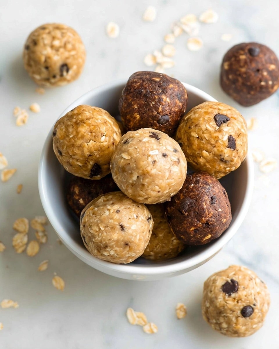The image shows a baking tray lined with parchment paper filled with 35 round cookie dough balls arranged in 5 rows and 7 columns. The cookie dough balls alternate colors in a pattern: lighter beige dough mixed with visible oats and chocolate chips, and darker brown dough mixed with oats and white chunks. Each dough ball has a rough, textured surface with visible mix-ins. The lighter dough has a creamy look with small dark chocolate chips and raisins, while the darker dough has a richer, toasted brown tone with small white bits scattered throughout. The background is a white marbled surface. photo taken with an iphone --ar 4:5 --v 7